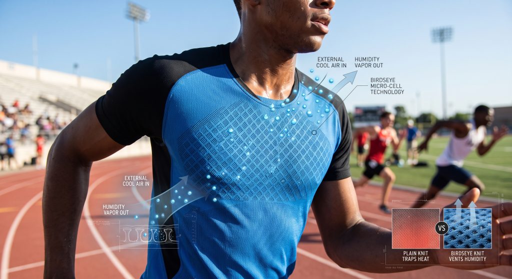 A close-up high-speed photograph of a competitive runner’s performance jersey made from Birdseye fabric on a stadium track, showing the micro-punctuated diamond knit cells with an overlaid dynamic diagram illustrating vapor escaping from skin through the pores.