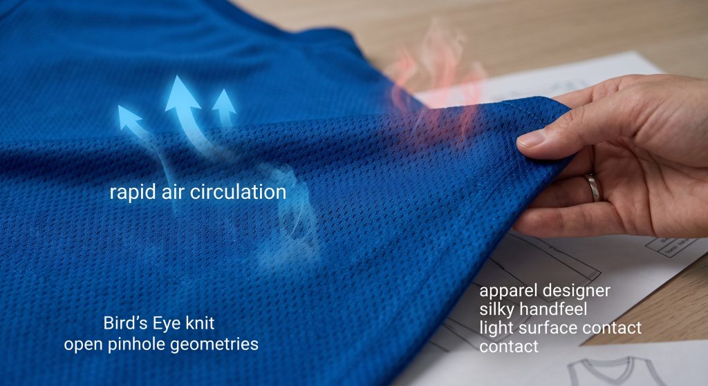 A detailed macro photograph showcasing the unique knit structure of blue Bird's Eye mesh fabric for basketball jerseys. Overlaid blue graphic arrows illustrate rapid air circulation passing through the open pinhole geometries, while a close view of a designer's hand feeling the material emphasizes its lightweight and silky handfeel.