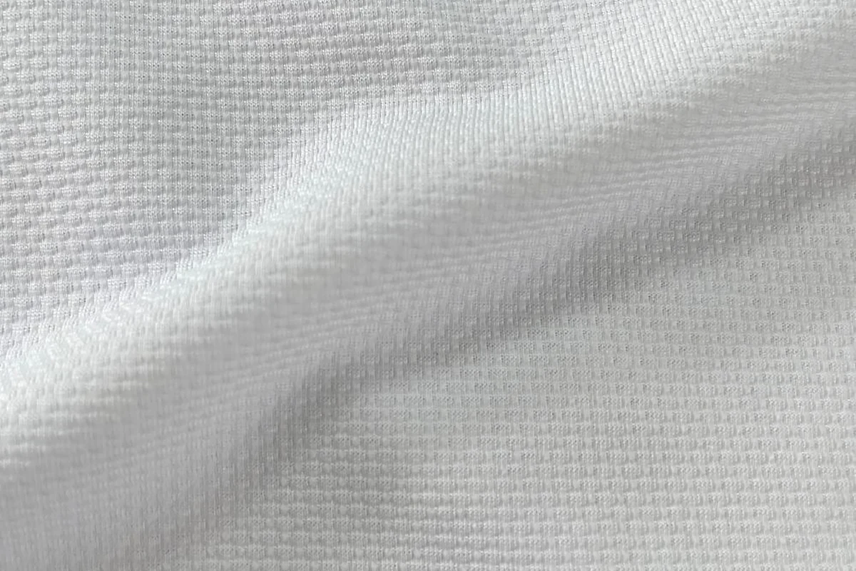 Flat view of white performance pique fabric for activewear