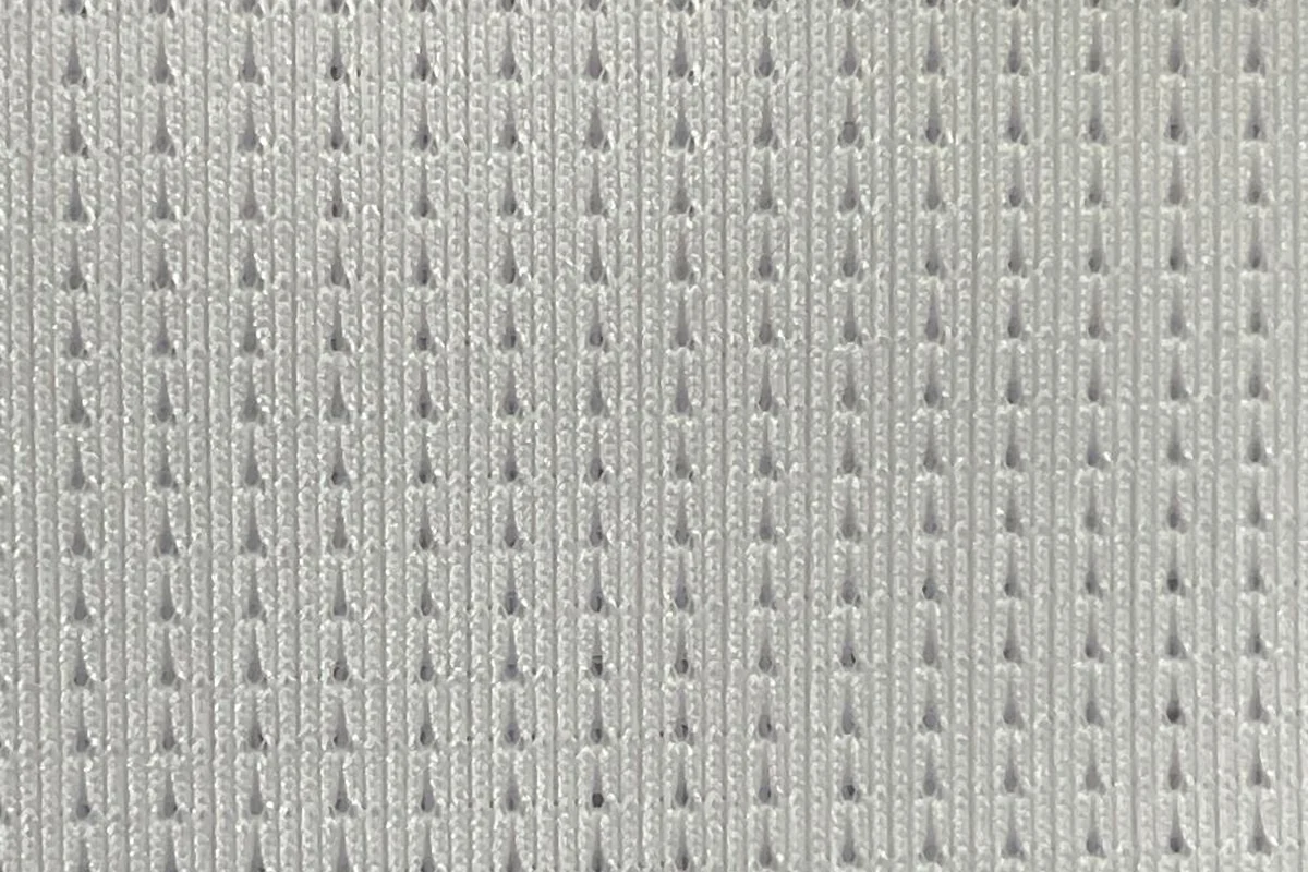 Close-up texture detail of white stretch vertical drop-needle pointelle activewear fabric KWC0040, 145gsm breathable knit.