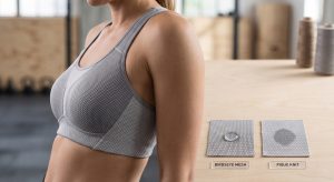 A photorealistic close-up of a technical sports bra and two labeled textile samples, Birdseye Mesh and Pique Knit, demonstrating sports bra wicking fabric performance.