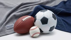 Photorealistic macro featured image linking the dimpled texture of a soccer ball and football conceptually to engineered micro-knit patterns (Birdseye mesh) of grey and navy functional sports fabric, visualizing functional geometry and structure on makitapefabric.com.